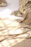 Antique gold draped balloon pants, close up of the soft metallic gold drape