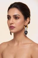 Model wearing Wear Wali black onyx carved kundan drop earrings in antique gold, with a polki flower above