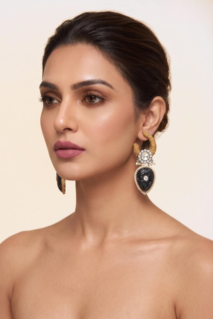 Model wearing Wear Wali black onyx carved kundan drop earrings in antique gold, with a polki flower above