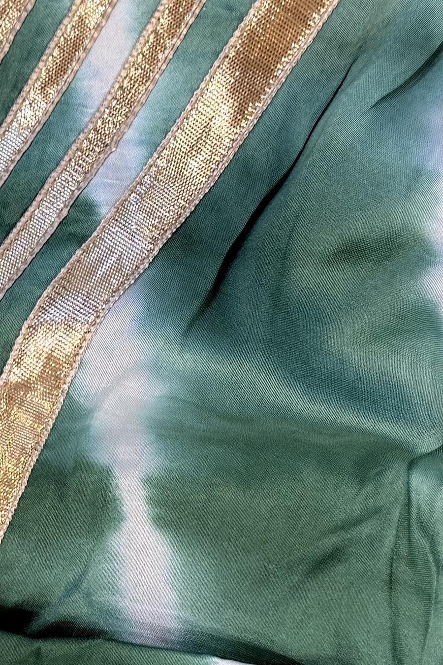 Green tie dye izzar, close up of the white tie dye pattern and gold stripe trim