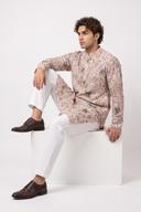 Blush pink embroidered net kurta with white shalwar, model seated, embroidery visible to the hem