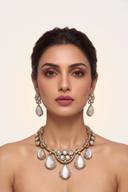 Model wearing the Wear Wali cat's eye teardrop necklace and earrings set in antique gold with polki clusters