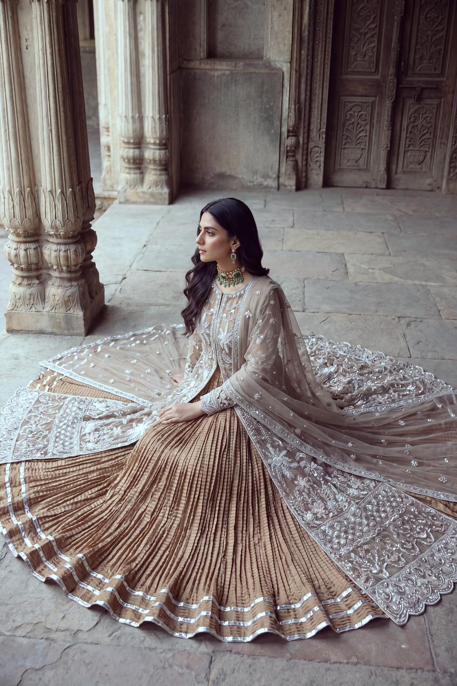 Champagne peshwas seated, pleated gold skirt with silver bands spread in a full circle