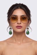 Model wearing Wear Wali emerald and sapphire Victorian drop earrings with a green mosaic stone teardrop