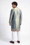 Back view of the green tissue silk kurta with gold buti motifs and deep embroidered hem border