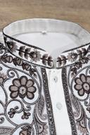 Macro close up of the chocolate brown embroidered placket and buttons on the ivory men's kurta