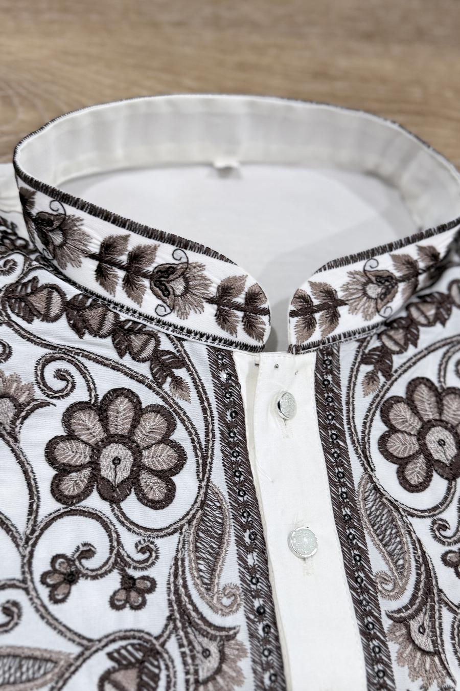 Macro close up of the chocolate brown embroidered placket and buttons on the ivory men's kurta