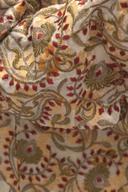 Ivory embroidered jacket, close up of the red, gold and olive floral pattern