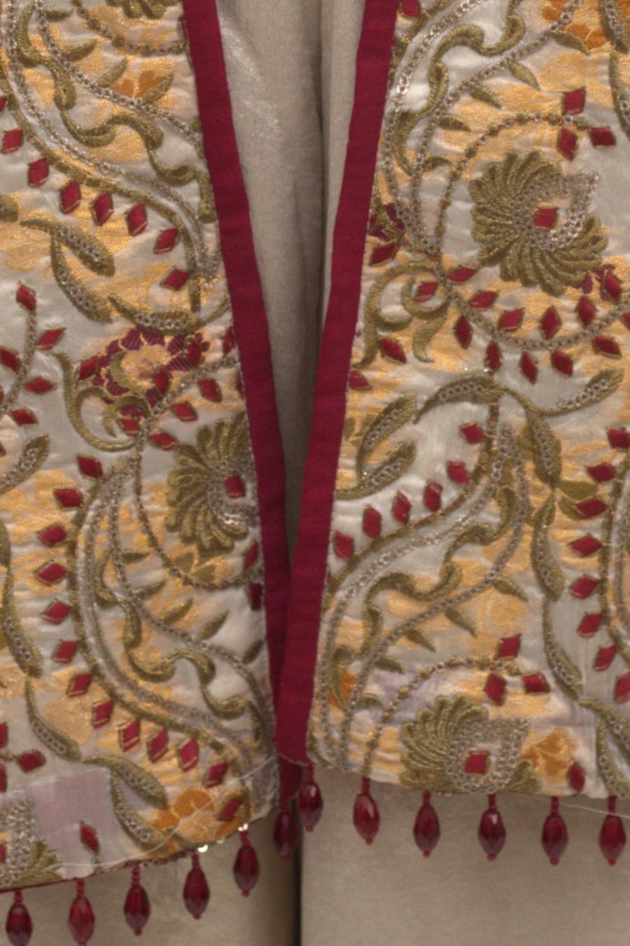 Ivory embroidered jacket, close up of the floral embroidery and bead fringe hem