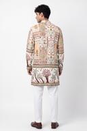 Back view of the ivory kurta with patchwork blocks above the hip band and embroidered trees below