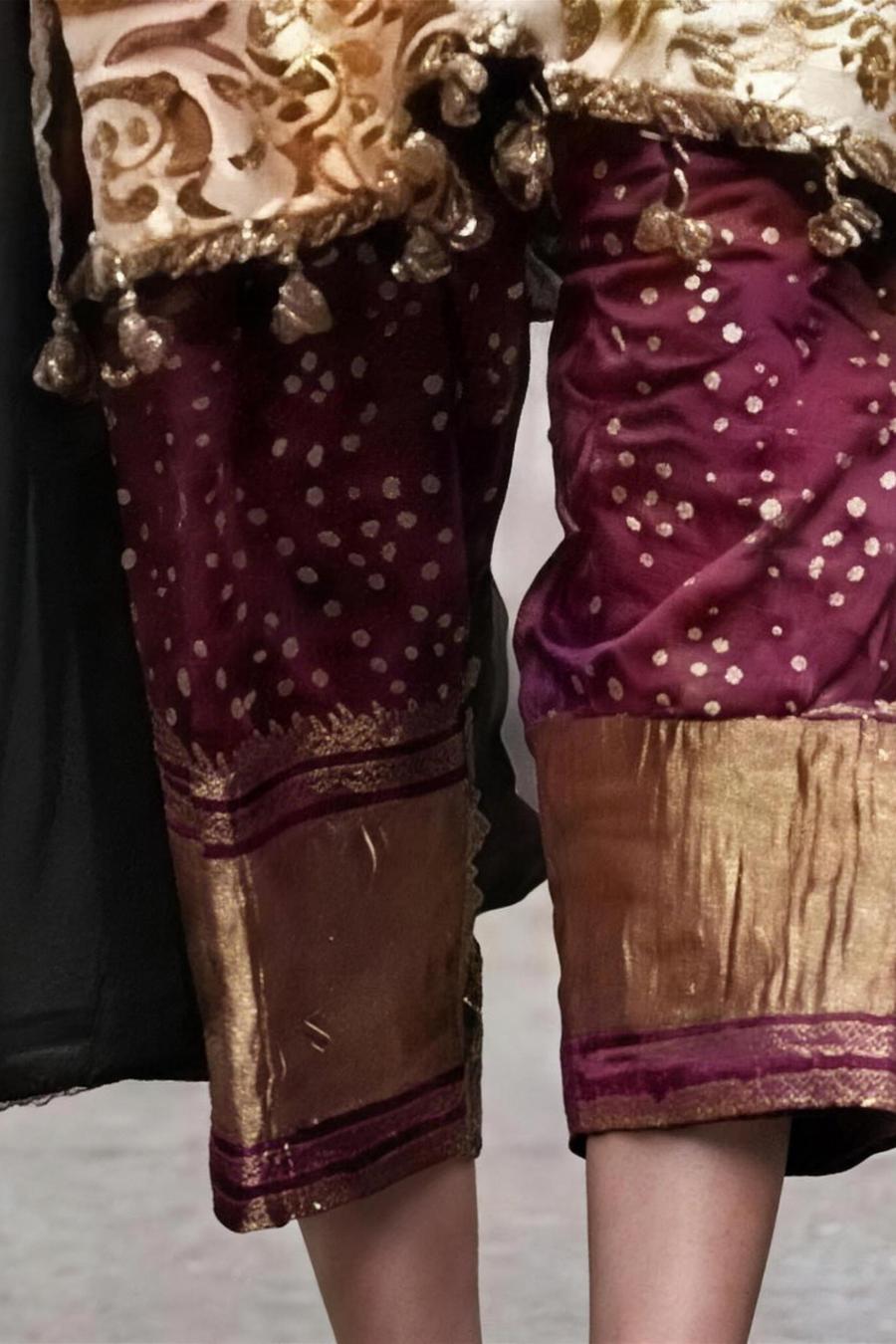 Wine embroidered trousers with gold dot work and gold hem border, close-up of the lower legs