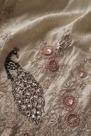 Close up of the ivory kurta hem: embroidered peacock, coral bead rosettes and scalloped beaded edge