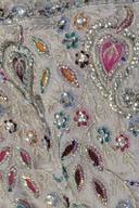 Ivory sequin lehenga, close up of multicolor paisleys and sequin flowers on the hem border