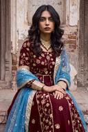 Maroon anarkali seated, showing gold paneled skirt embroidery and blue dupatta with gold lace edge