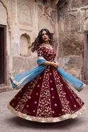 Maroon anarkali in motion, skirt flared out with gold border hem, blue dupatta lifted