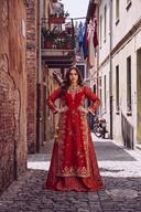 Red orange muqesh long shirt over a lehenga, gold embroidered panels, full length front view