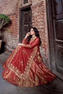 Red long shirt lehenga seated, flared gold brocade skirt and muqesh border spread across the floor
