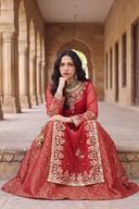 Red muqesh long shirt seated, close view of gold embroidered neckline, border panel and tassels
