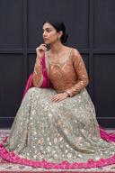 Tangerine chevron sequin top with round neckline and sage floral skirt, seated close up