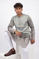 Sage tissue silk kurta with white shalwar, model seated, pewter paisley hem border visible