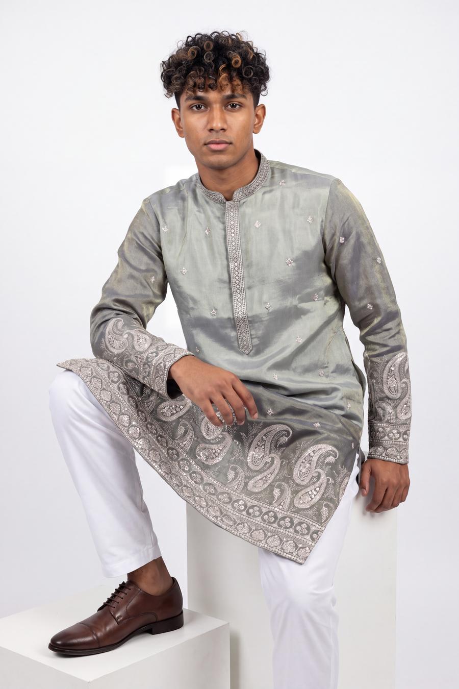 Sage tissue silk kurta with white shalwar, model seated, pewter paisley hem border visible
