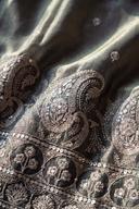 Close up of the sage kurta hem: pewter silver paisley and rosettes with a sequin packed edge