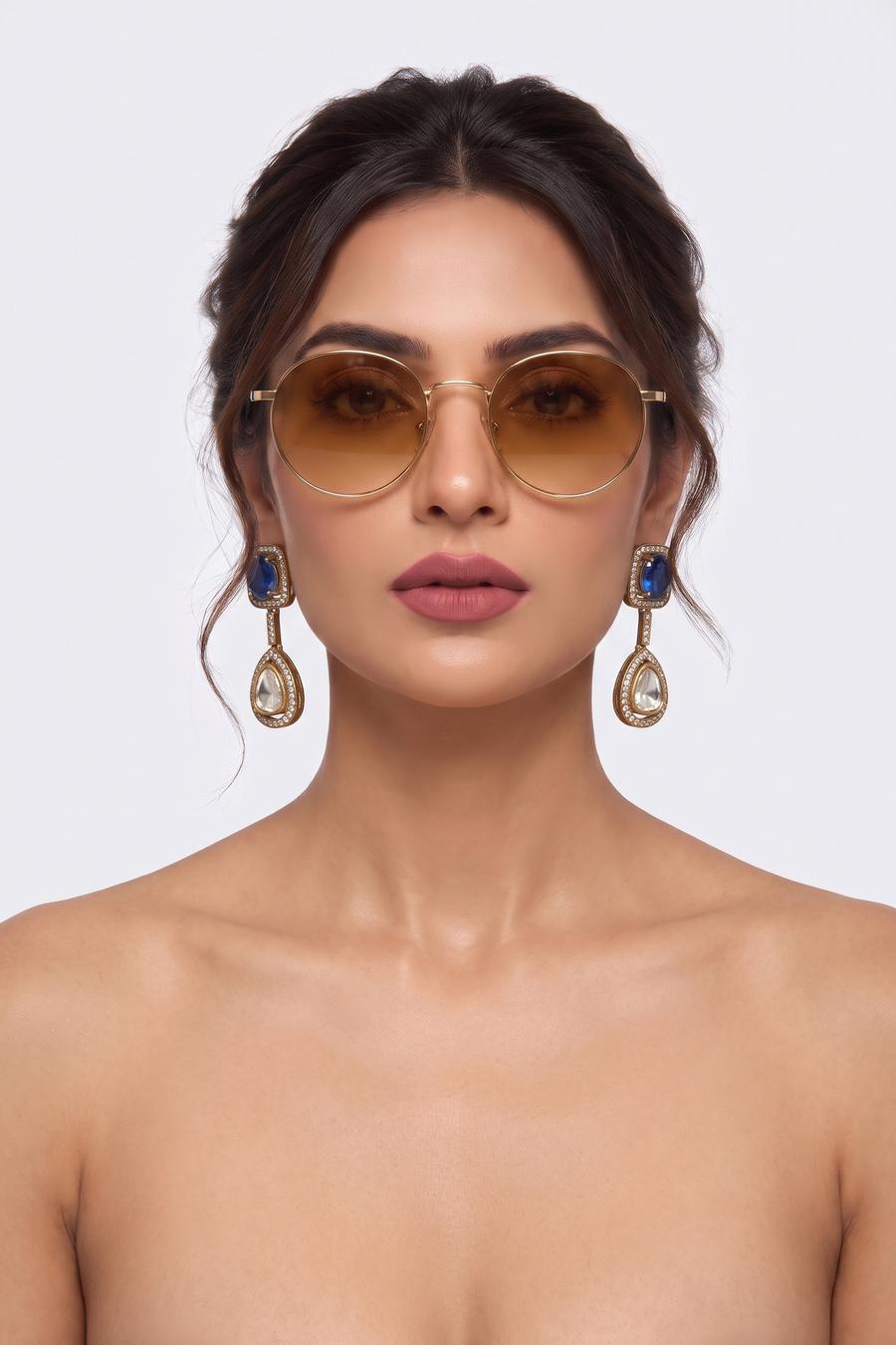 Model wearing Wear Wali sapphire blue Victorian drop earrings in antique gold, with a clear polki teardrop