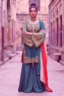 Teal kurta with tangerine and green handwork and wide teal palazzo, arms crossed, full length